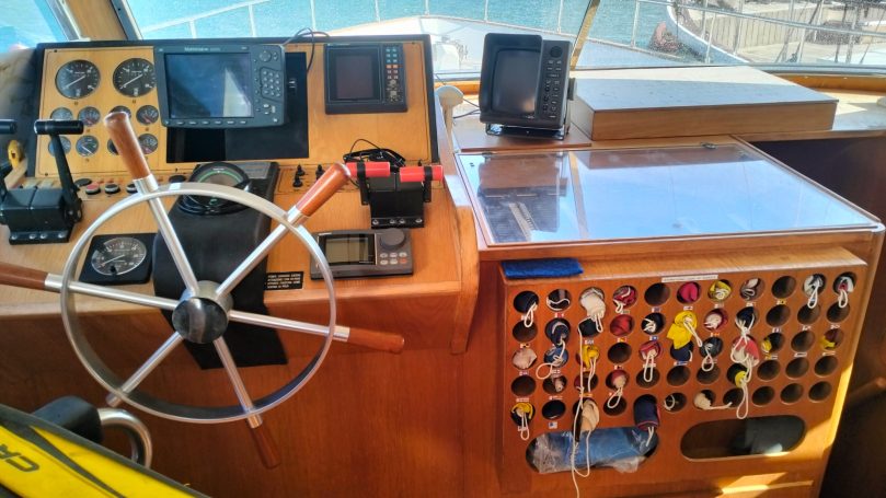 Yacht Shalimar IV Pannello di controllo di una barca con timone, strumenti e comandi.